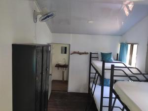 a dorm room with two bunk beds and a room with a window at Uvita Pirates Hostel in Uvita