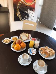a table topped with plates of food and drinks at Kube Apartments Express in Córdoba