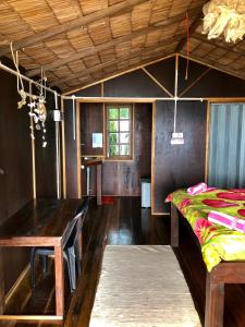 Zimmer mit Tisch und Bett in der Unterkunft Beachfront Hut Upstairs Astra - Beach Shack Chalet in Tioman Island