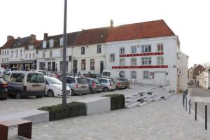 a parking lot with cars parked in front of a building at Gîte de la Belle Roze in Ardres