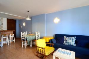 a living room with a blue couch and a table and chairs at MEDES PARK I 2-7 in L'Estartit