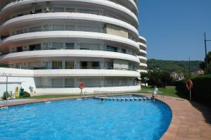 un edificio con piscina di fronte a un edificio di MEDES PARK I 4-5 a L'Estartit