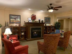 a living room with a fireplace with chairs and a table at 1863 Inn of Gettysburg in Gettysburg