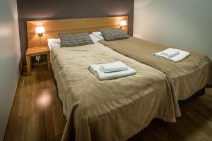 two beds with towels on top of them in a room at Ruka Chalets Ski-Inn in Ruka