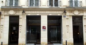 um edifício com entrada para um hotel de luxo em Excelsior Batignolles em Paris