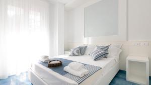 - un lit blanc avec des serviettes et un panier dans l'établissement Rivazzurra Homes - B, à Termoli