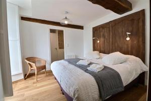 een slaapkamer met een groot bed met een houten hoofdeinde bij Chateau des Fontenelles in Chavagne