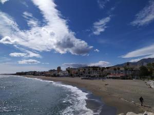 una persona che cammina sulla spiaggia vicino all'oceano di Bajondillo Sun & Beach a Torremolinos