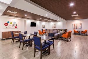 a dining room with tables and chairs and a tv at Holiday Inn Express Hotel and Suites Petersburg - Fort Lee, an IHG Hotel in Petersburg