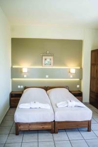 1 dormitorio con 2 camas y toallas. en Filoxenia, en Tinos