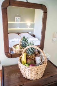 una cesta de fruta en una mesa frente a un espejo en Filoxenia, en Tinos