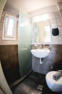ein Bad mit einem Waschbecken und einem WC in der Unterkunft Filoxenia in Tinos