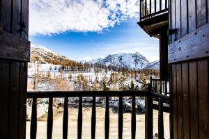 a view of a snow covered mountain from a balcony at Hotel Belvedere in Sestriere