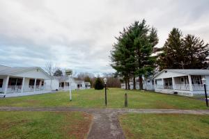 um grupo de casas brancas com um jardim de relva em Myer Country Motel em Milford