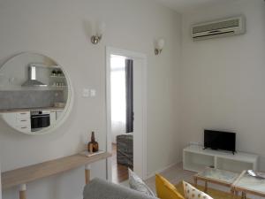 uma sala de estar branca com um espelho e uma televisão em Caché ✦ Bright One-Bedroom Apartment in Sofia em Sófia
