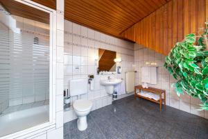een badkamer met een toilet, een wastafel en een bad bij Gasthof zum Siegburger in Straelen