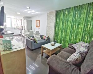 a living room with two couches and a green curtain at Neptuno Apartment: Sun, beach and relax in Huelin in Málaga