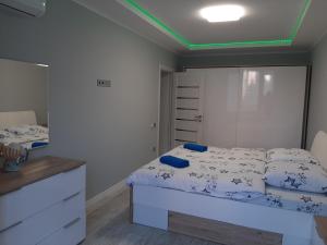 a bedroom with a white bed and a mirror at Люкс 2 in Uzhhorod