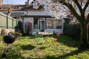 a backyard with a grill and a table and chairs at Maison de ville in Périgueux