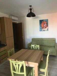 - un salon avec une table et un canapé vert dans l'établissement residenza monarka, à Marina di Davoli
