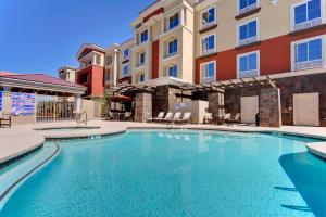 una piscina di fronte a un condominio di Holiday Inn Express & Suites Las Vegas SW Springvalley, an IHG Hotel a Las Vegas