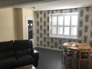 a living room with a couch and a table at Thurso Self Catering Pet Friendly Holiday Lets in Thurso