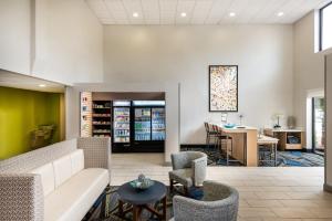 a lobby with a couch and chairs and a table at Holiday Inn Express & Suites Charlotte Arpt-Belmont by IHG in Belmont