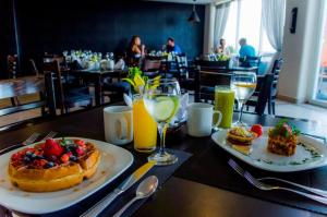 a table with two plates of food and glasses of orange juice at Coral Princess Hotel & Dive Resort in Cozumel