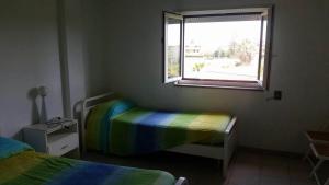una piccola camera con due letti e una finestra di Residence Bluemarine a Sellia Marina