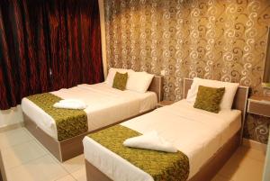 um quarto de hotel com duas camas em Lacomme Inn em Kuala Lumpur