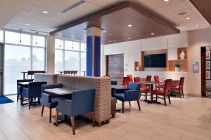 a dining room with tables and chairs and windows at Holiday Inn Express & Suites - Marshalltown, an IHG Hotel in Marshalltown