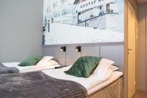 twee bedden in een kamer met een foto aan de muur bij Hotell Leksand in Leksand