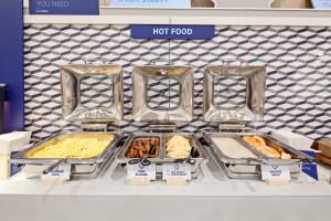a display of food in trays on a counter at Holiday Inn Express Hollywood Walk of Fame by IHG in Los Angeles