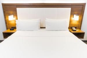 a large bed with two pillows and two tables at Holiday Inn Express Hollywood Walk of Fame by IHG in Los Angeles
