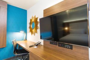 a room with a desk with a large flat screen tv at Holiday Inn Express Hollywood Walk of Fame by IHG in Los Angeles