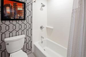 a bathroom with a white toilet and a bath tub at Holiday Inn Express Hollywood Walk of Fame by IHG in Los Angeles