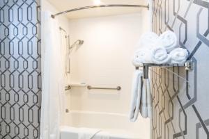 a bathroom with a shower and a toilet with towels at Holiday Inn Express Hollywood Walk of Fame by IHG in Los Angeles