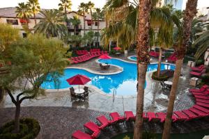 uma vista superior para uma piscina com cadeiras vermelhas e árvores em Tuscany Suites & Casino em Las Vegas