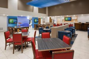 a dining room with tables and chairs and televisions at Holiday Inn Express Hotel & Suites Minneapolis-Golden Valley, an IHG Hotel in Minneapolis