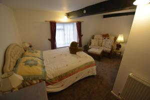un dormitorio con un osito de peluche sentado en una cama en Pier Cottage, en Watchet