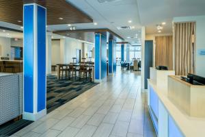 un hall de bureau avec colonnes et tables bleues dans l'établissement Holiday Inn Express & Suites - Medford, an IHG Hotel, à Medford