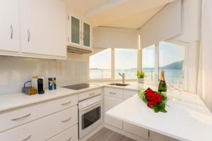 a white kitchen with a counter with flowers on it at BestVillas Foz do Minho in Caminha