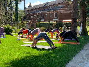 Un groupe de personnes faisant du yoga dans l'herbe dans l'établissement Vila Suzana Parque Hotel, à Canela