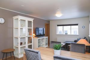 a living room with a dining table and a television at E18 Apartments in Akureyri