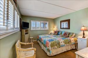 Un dormitorio con una cama y un televisor y ventanas. en Oceans Of Amelia, en Fernandina Beach 30 fotos más