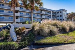 un gran edificio de apartamentos con palmeras enfrente en Oceans Of Amelia, en Fernandina Beach
