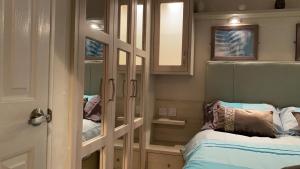 a small room with a bed and a mirror at Woodland Retreat in Swarland