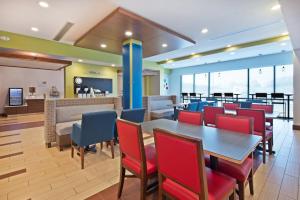 a dining room with tables and red chairs at Holiday Inn Express & Suites Uniontown, an IHG Hotel in Uniontown