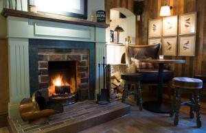 a living room with a fireplace and a fire place at Red Lion Inn in Little Budworth