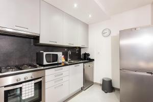 una cucina con armadietti bianchi e forno a microonde di FLH Liberdade Terrace Apartment a Lisbona